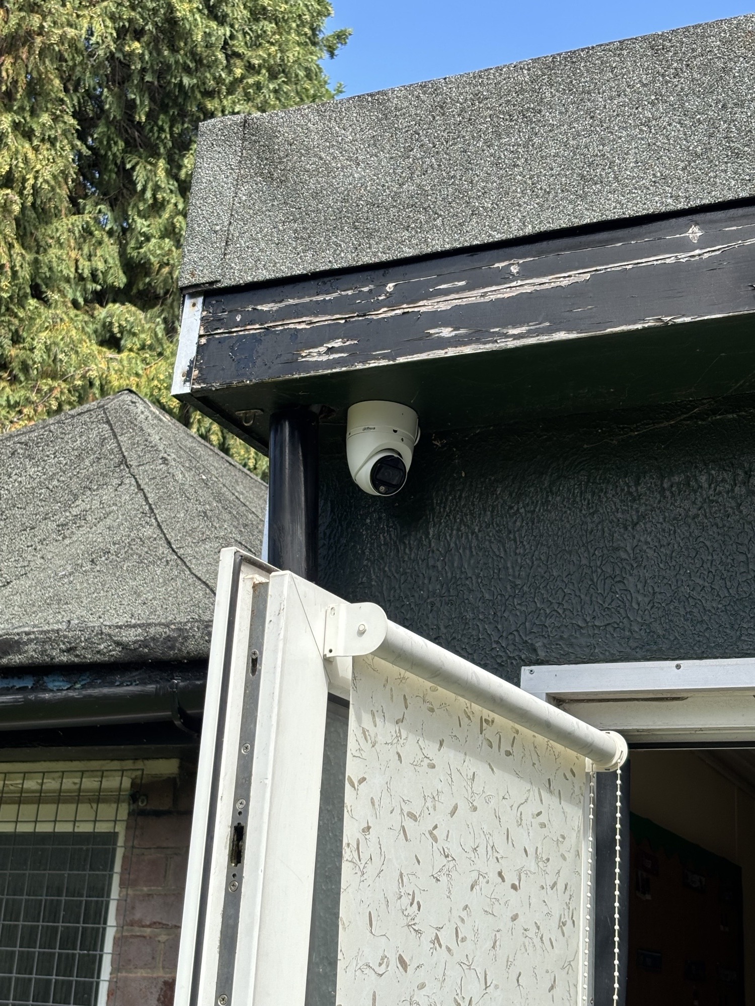 CCTV camera mounted under a weathered roof eave